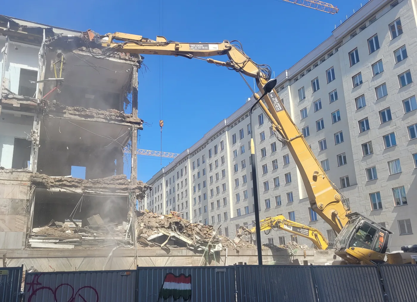High reach demolition excavator taking down a concrete structure
